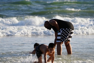 a man and a boy playing in the water at the beach