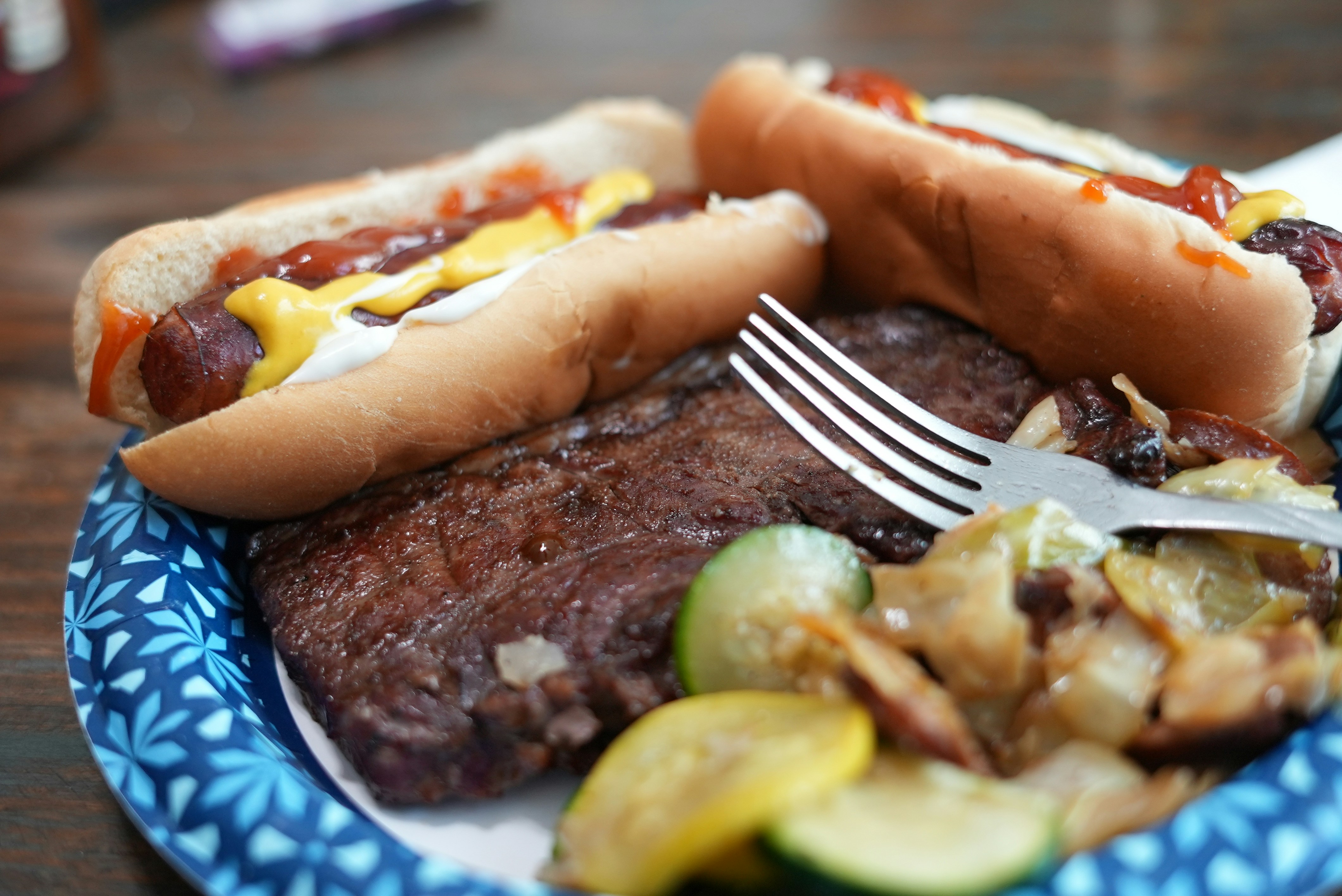 a plate with two hot dogs and a side of vegetables