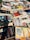 A collection of various books and magazines spread out on a table, with different sizes, colors, and cover designs. The selection includes novels, educational books, and periodicals, some with Spanish titles. The arrangement seems casual, possibly indicating a market or a book fair setting.