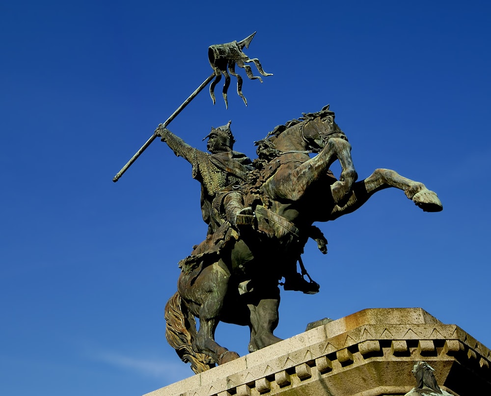 a statue of a man riding a horse holding a spear