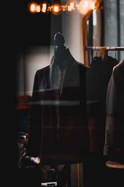 Sleek leather blazer showcased on a rack with soft lighting highlighting its texture.