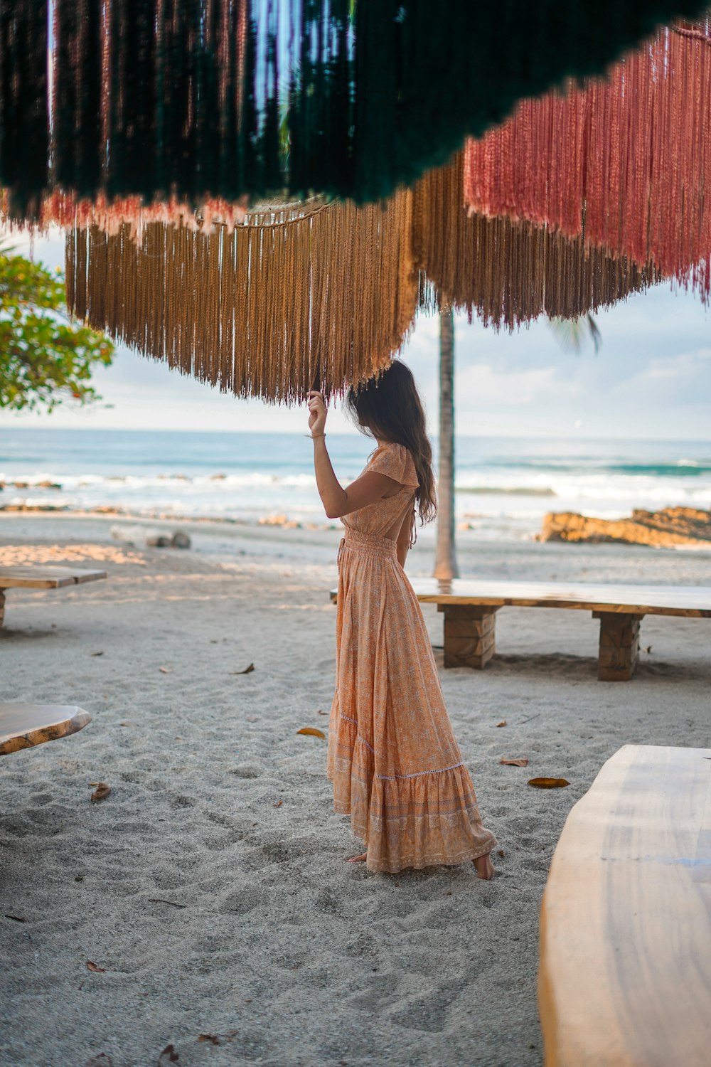 a woman in a long dress holding an umbrella over her head