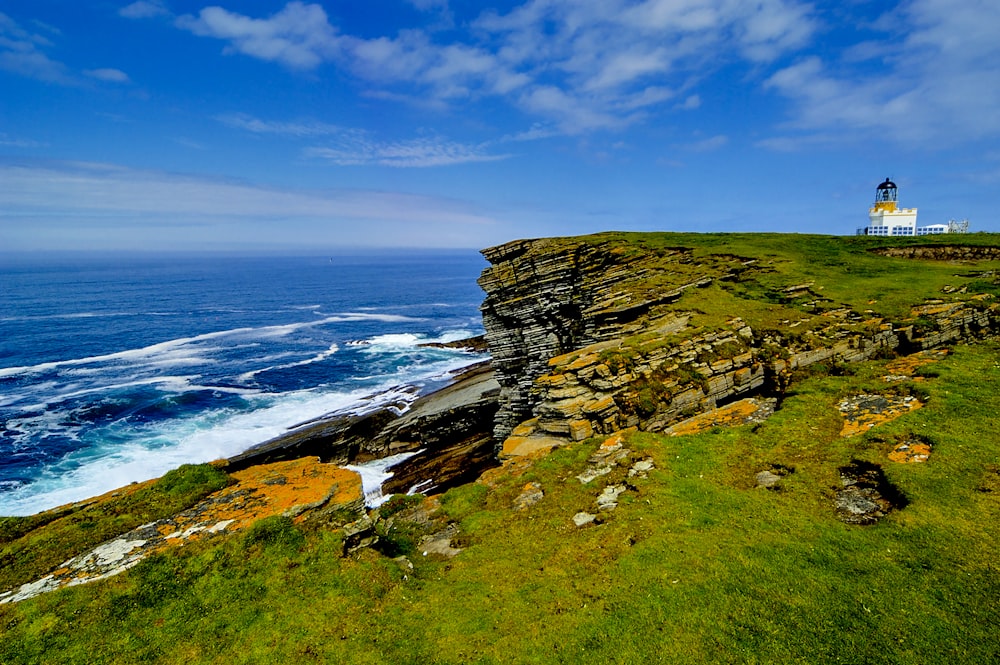 a lighthouse on top of a cliff near the ocean