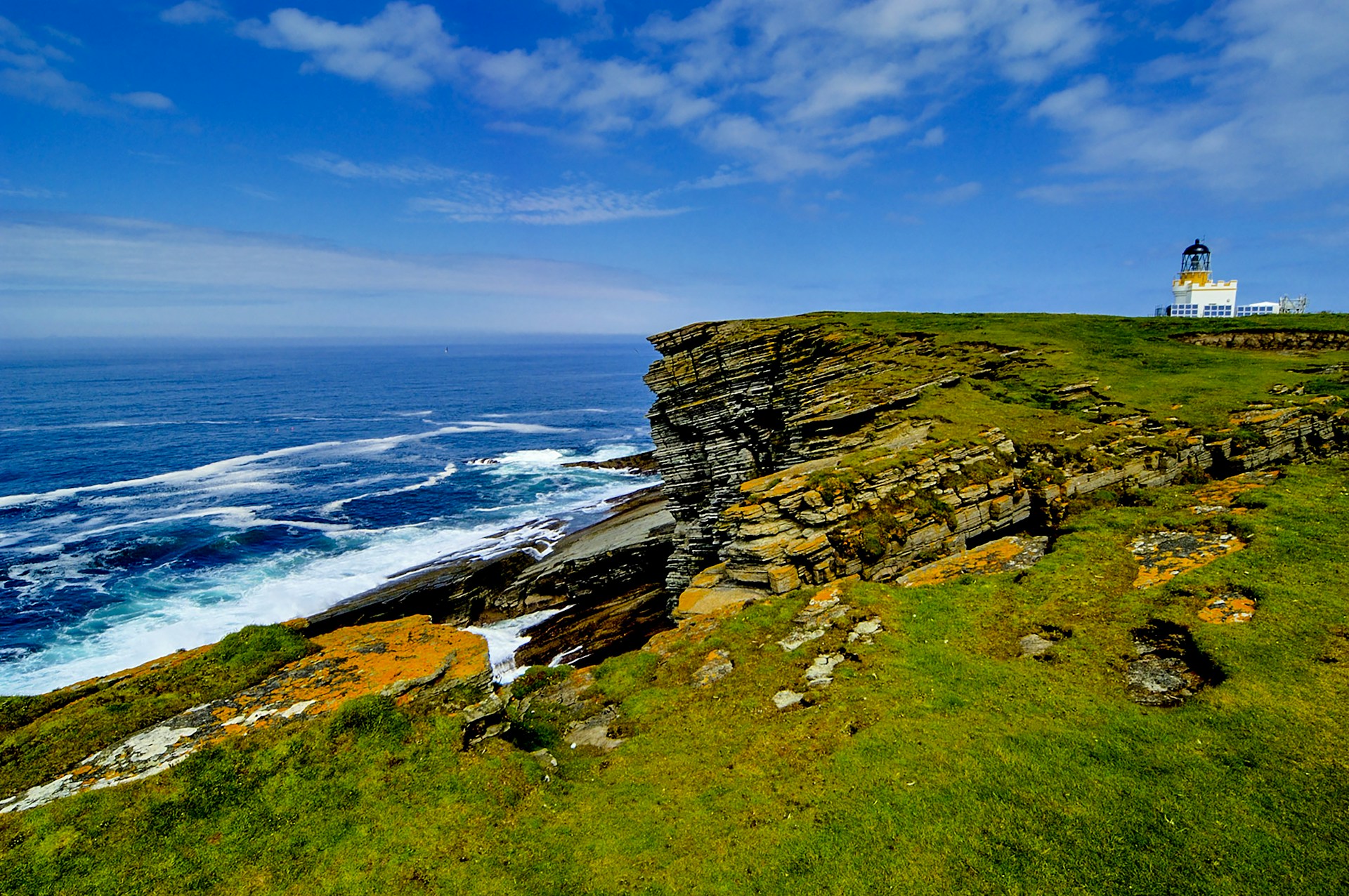 a lighthouse on top of a cliff near the ocean