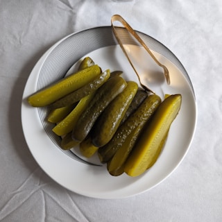a white plate topped with pickles next to a fork