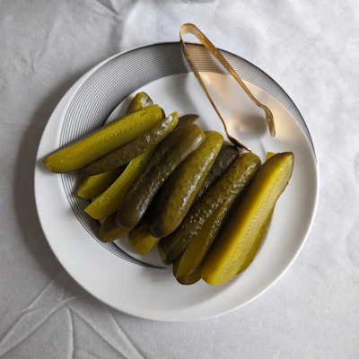 a white plate topped with pickles next to a fork