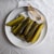 pickles and serving tongs on a white plate