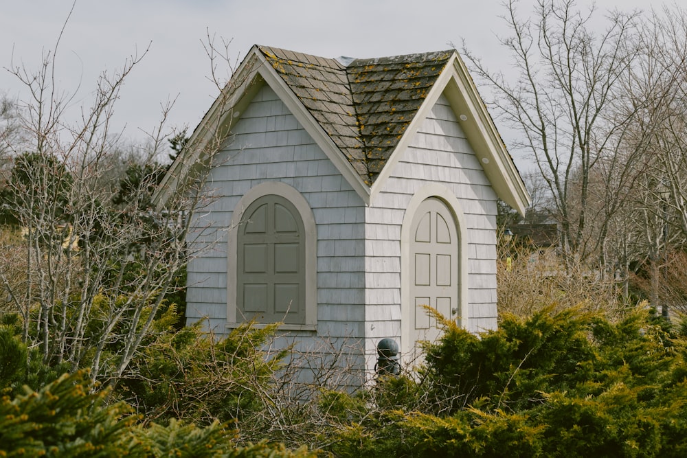 uma pequena casa branca com um telhado marrom