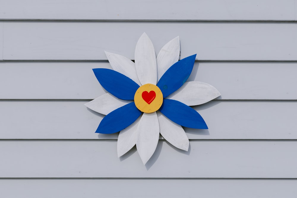 a white and blue flower with a red heart on it