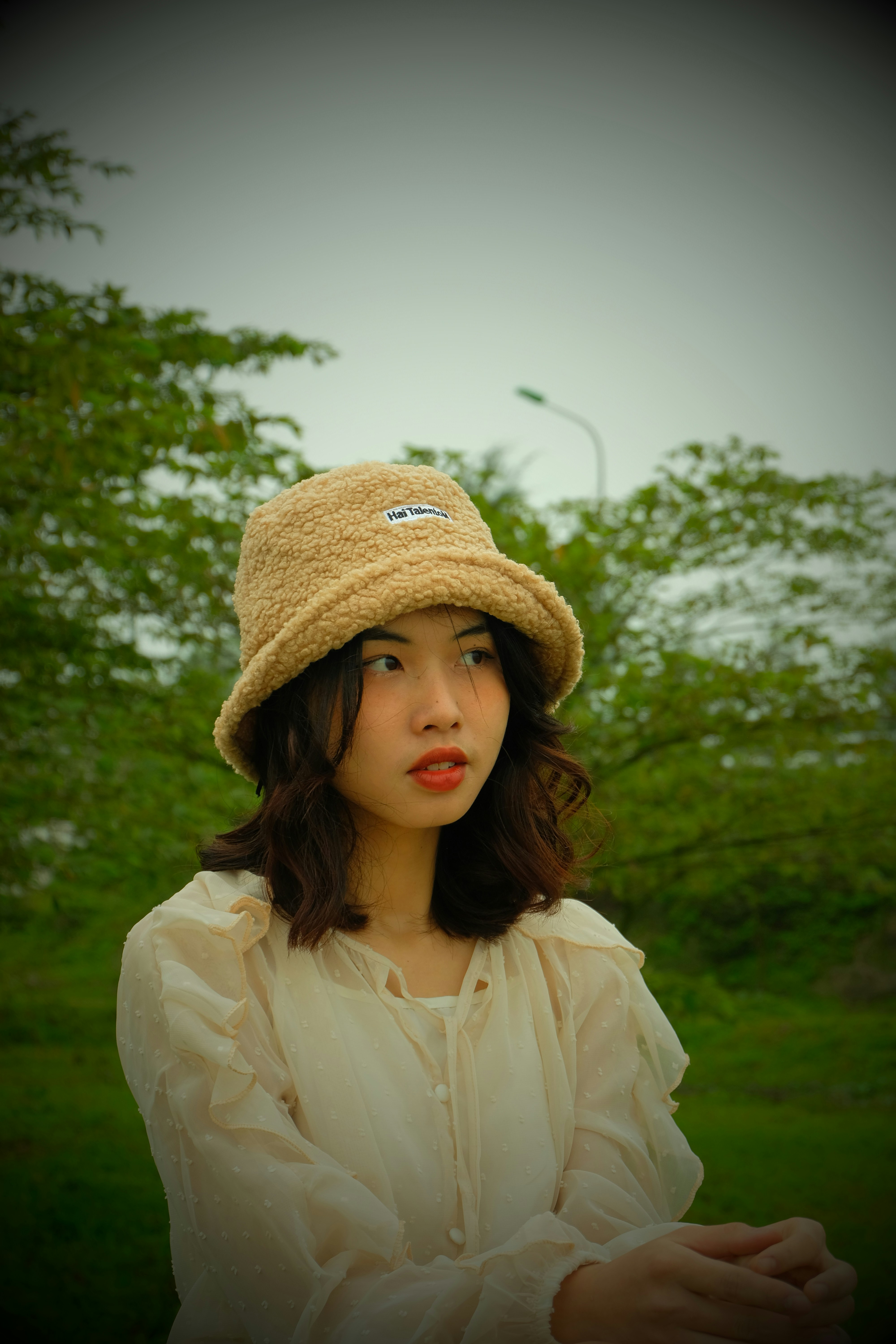 a woman wearing a hat standing in a field