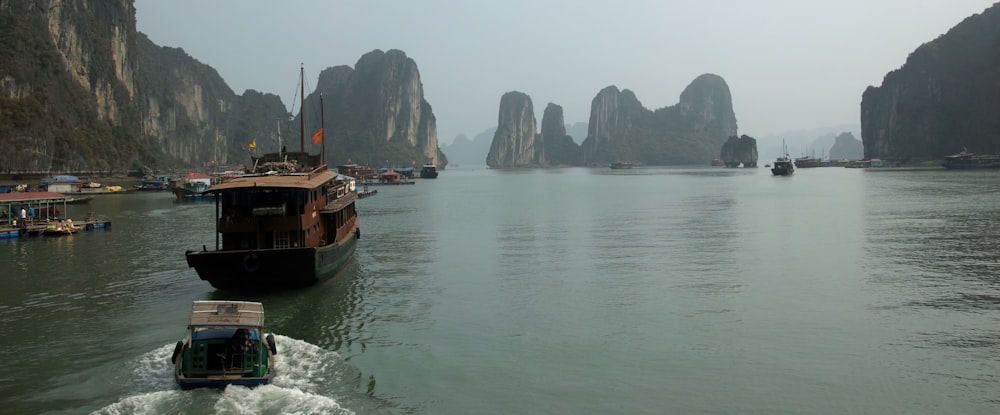 a boat traveling through a body of water surrounded by mountains