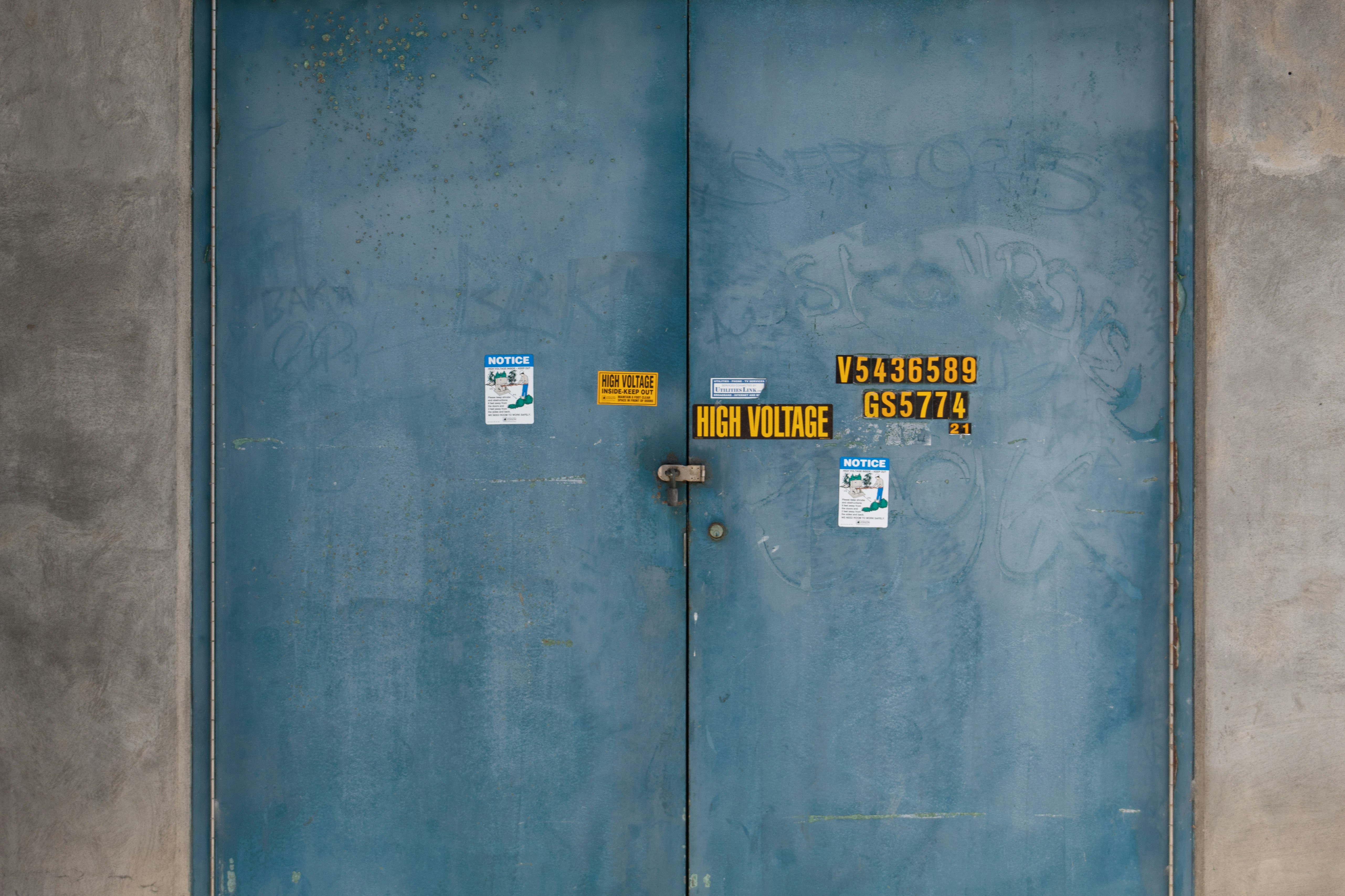 a blue door with two yellow signs on it