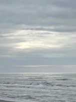 A contemplative artwork showing gentle waves on a calm sea under a pale sky.