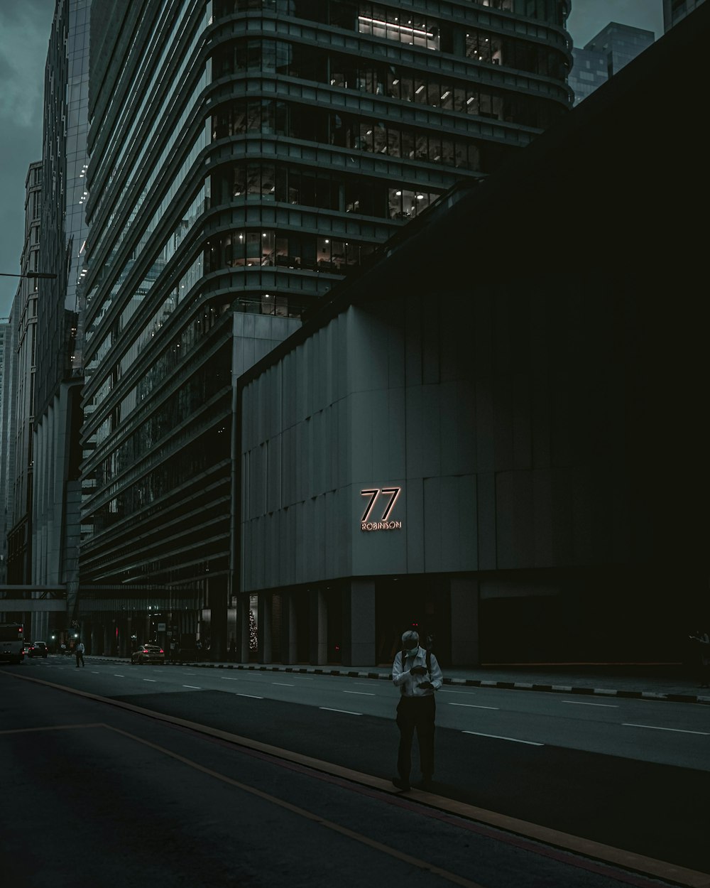 Ein Mann steht am Straßenrand neben einem hohen Gebäude