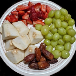 a white plate topped with fruit and nuts