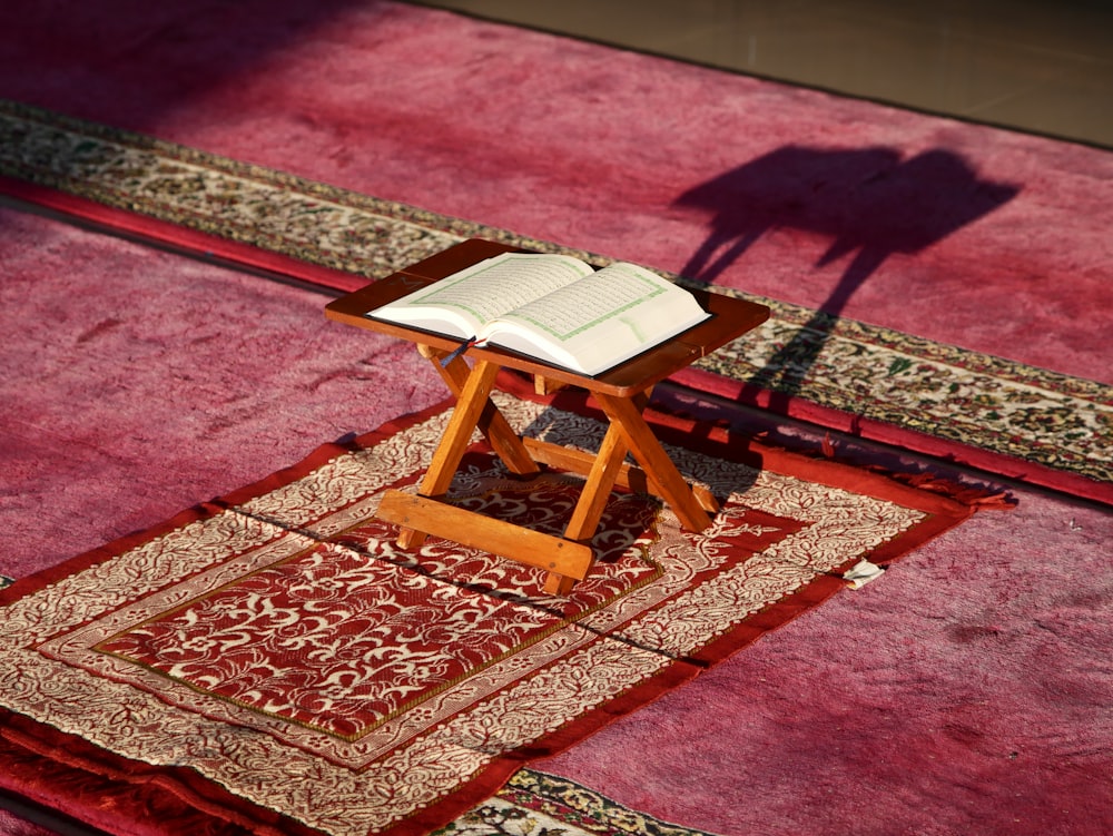 a small wooden table with a book on top of it