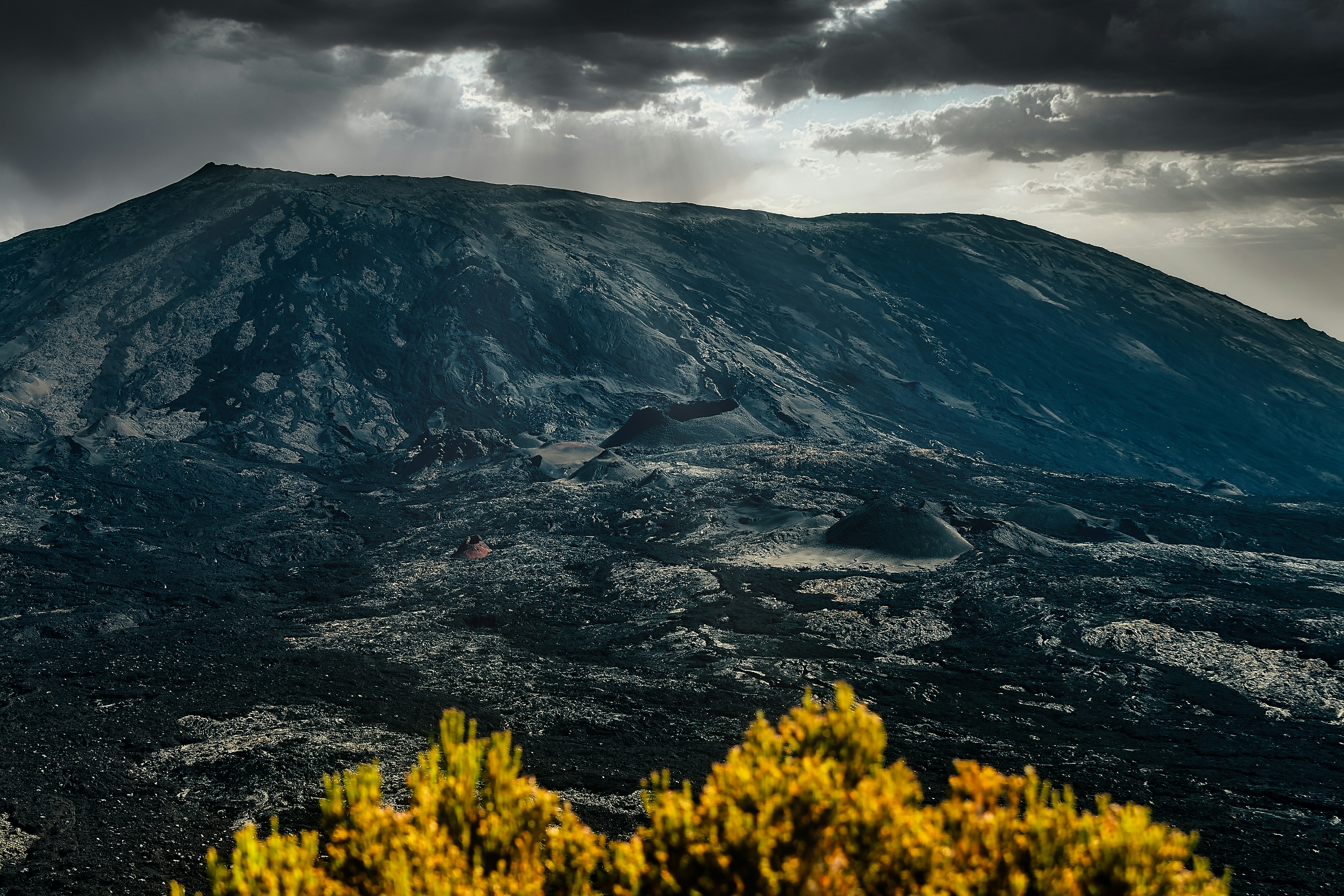 a very large mountain with a cloudy sky above it