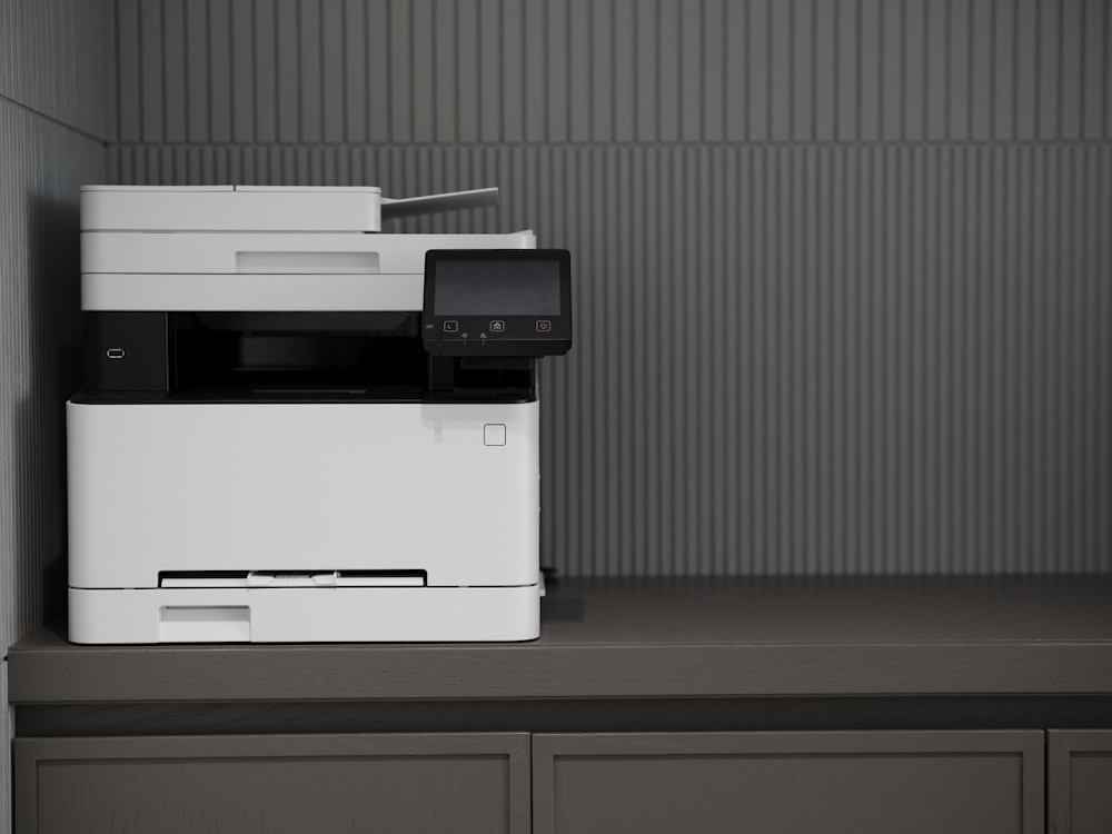 une imprimante blanche et noire posée sur un comptoir