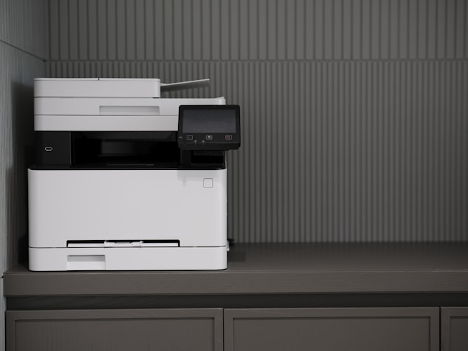 Weisser Multifunktionsdrucker auf einem Sideboard im Büro