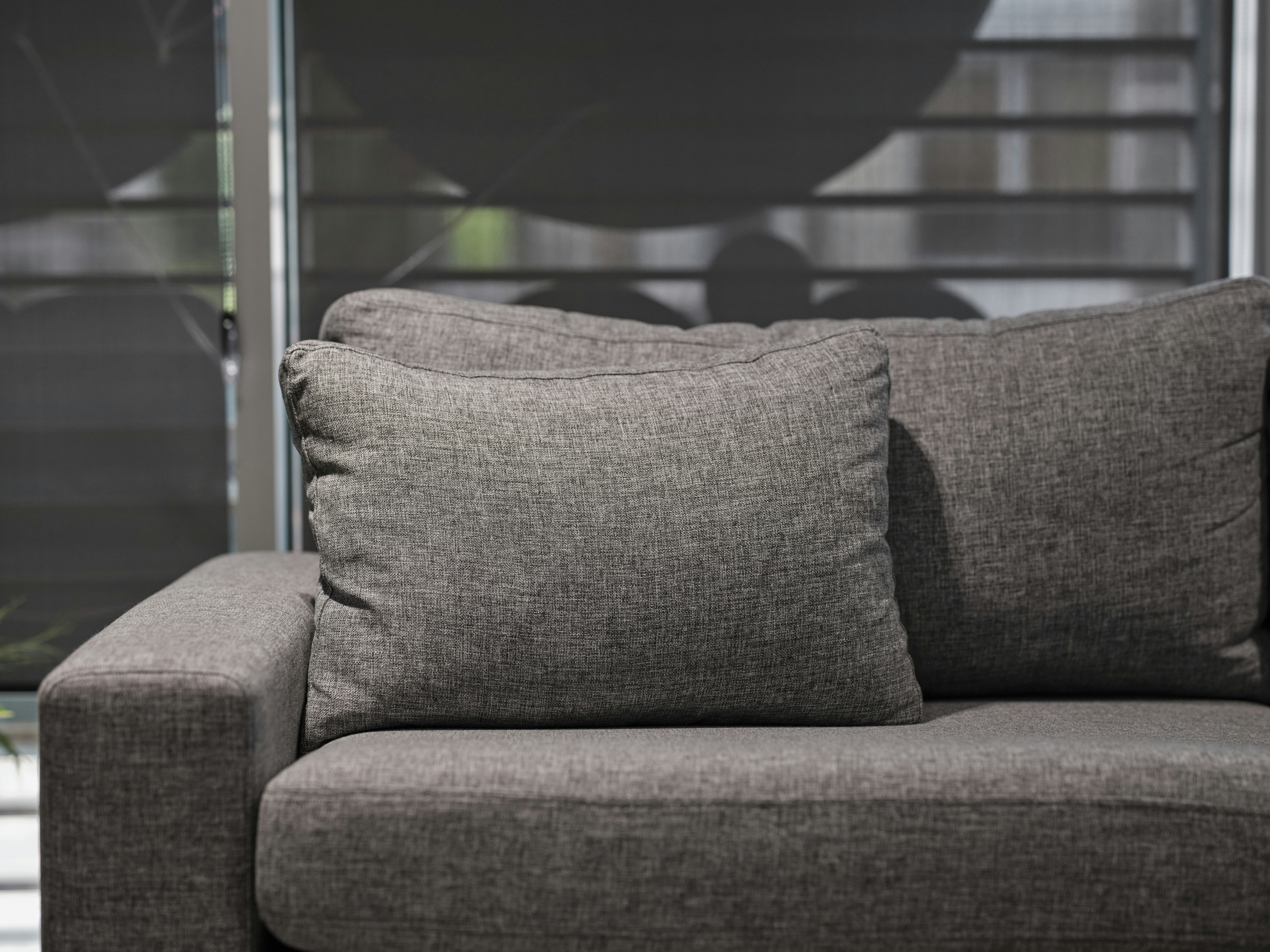 a gray couch with two pillows on top of it