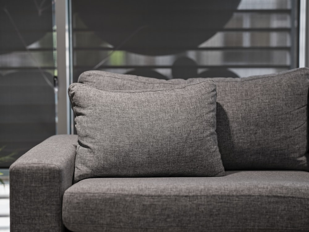 a gray couch with two pillows on top of it