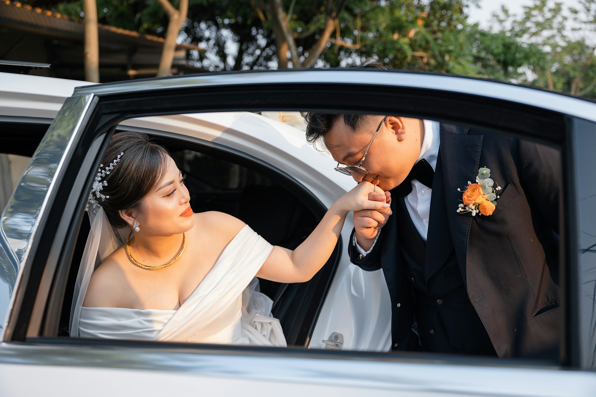 a bride and groom getting out of a car