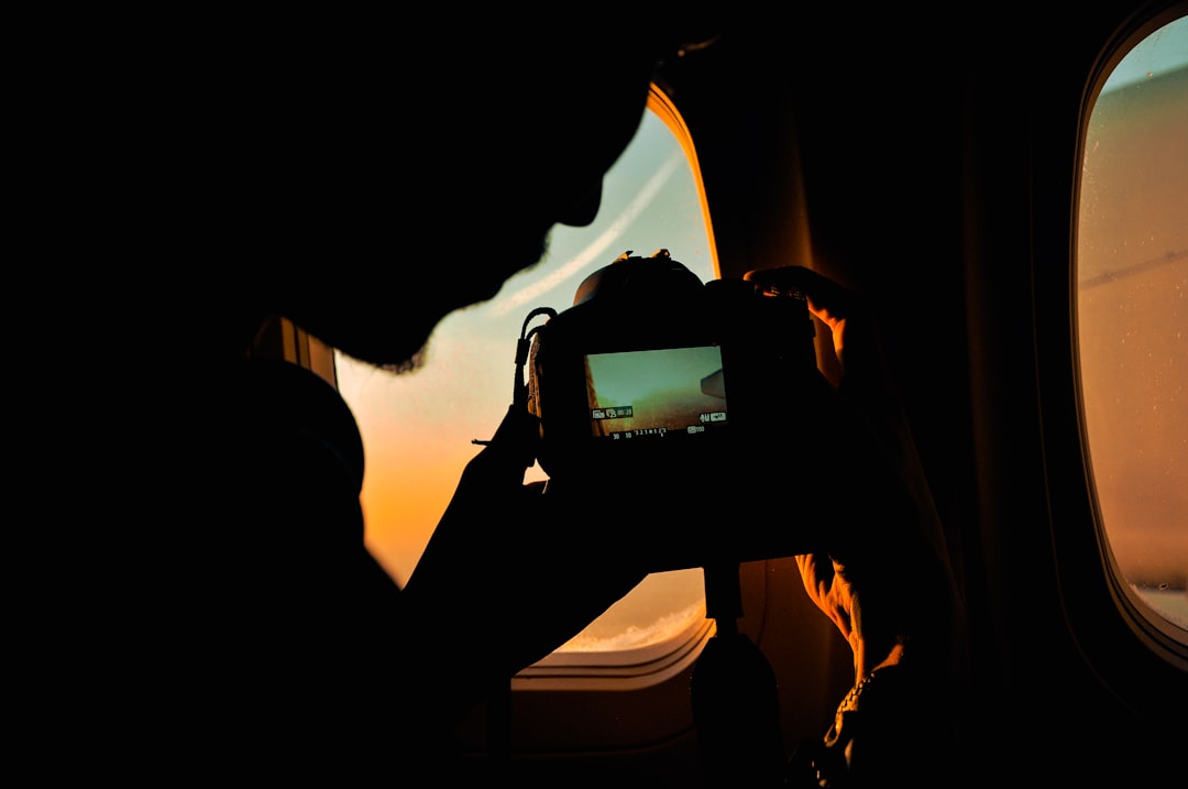 a person taking a picture of a plane window,
