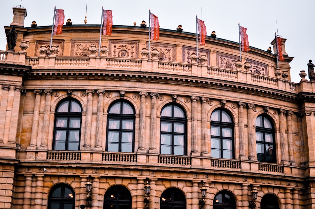 a large building with lots of windows and flags on top of it,