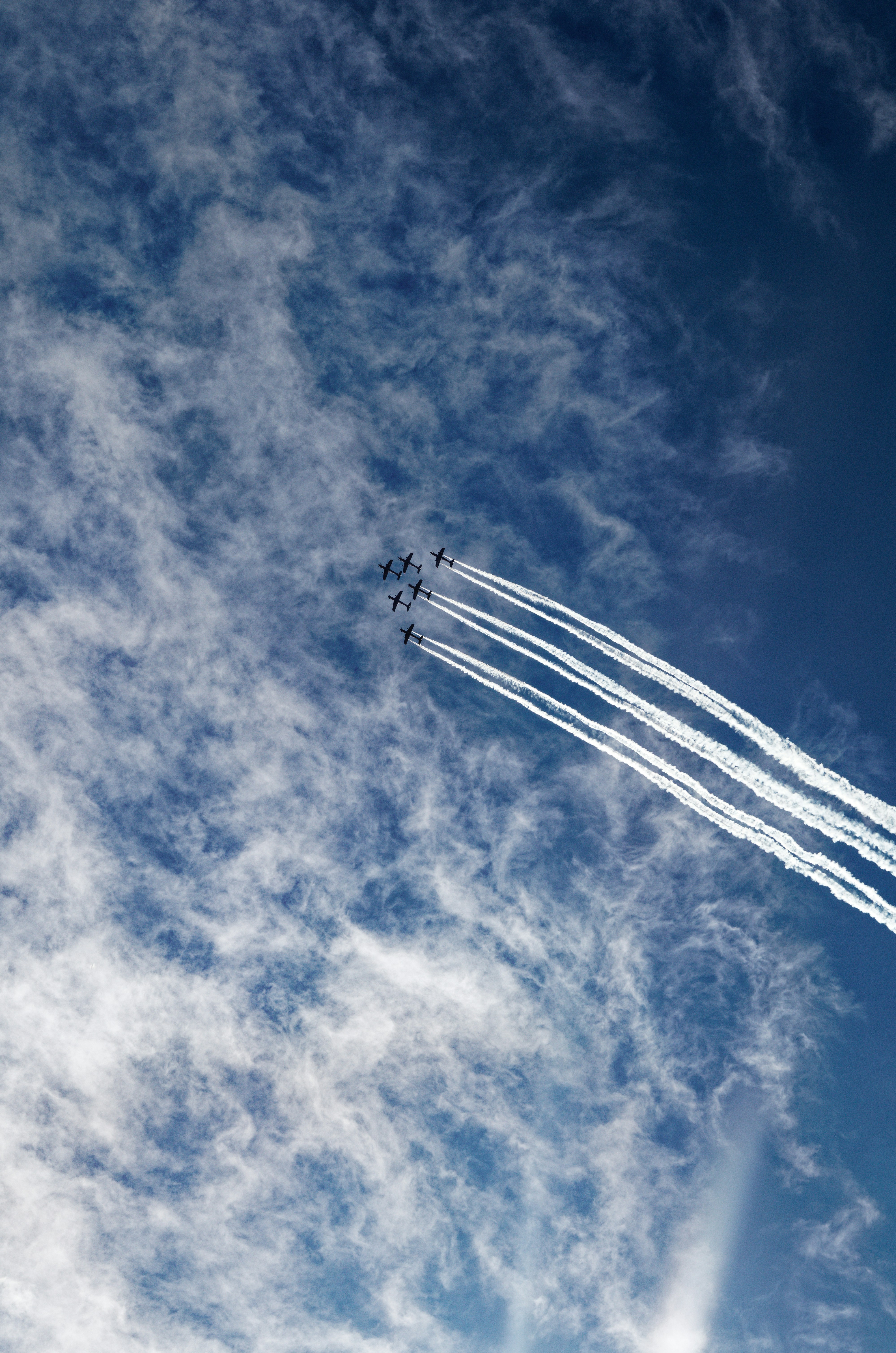 a group of airplanes flying through a cloudy blue sky