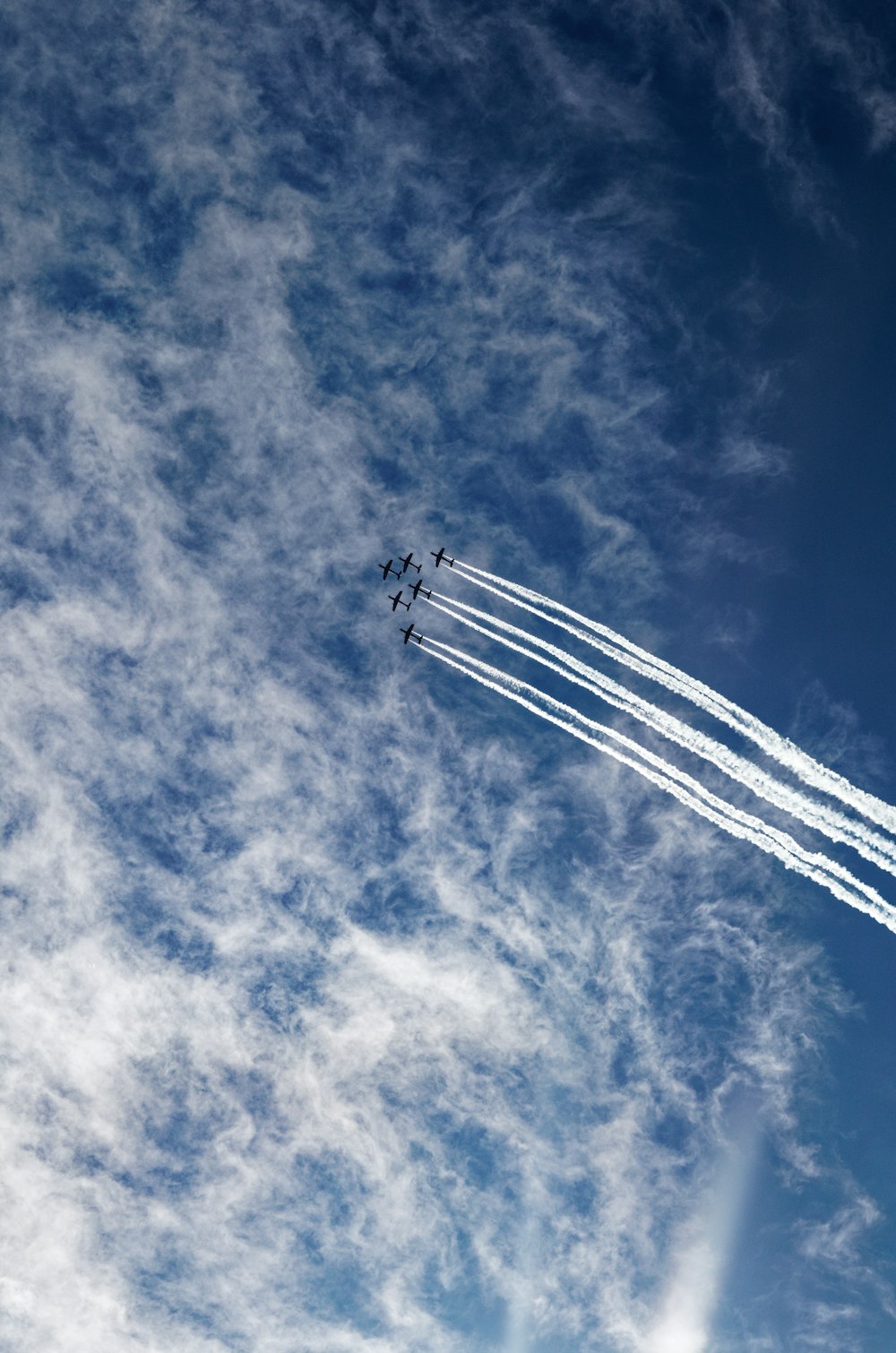 a group of airplanes flying through a cloudy blue sky