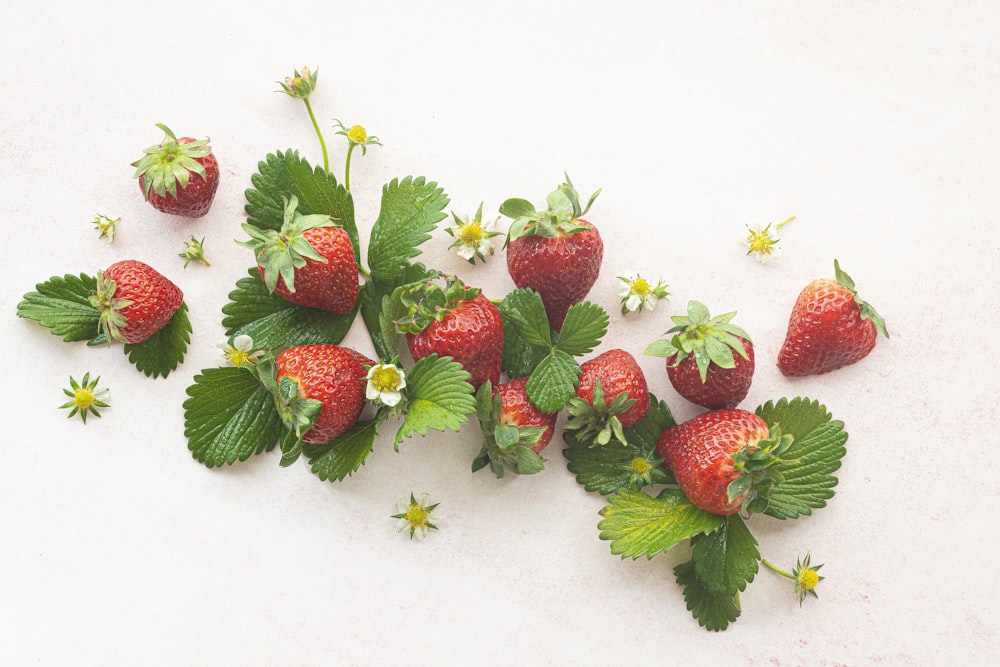 a group of strawberries on a white surface
