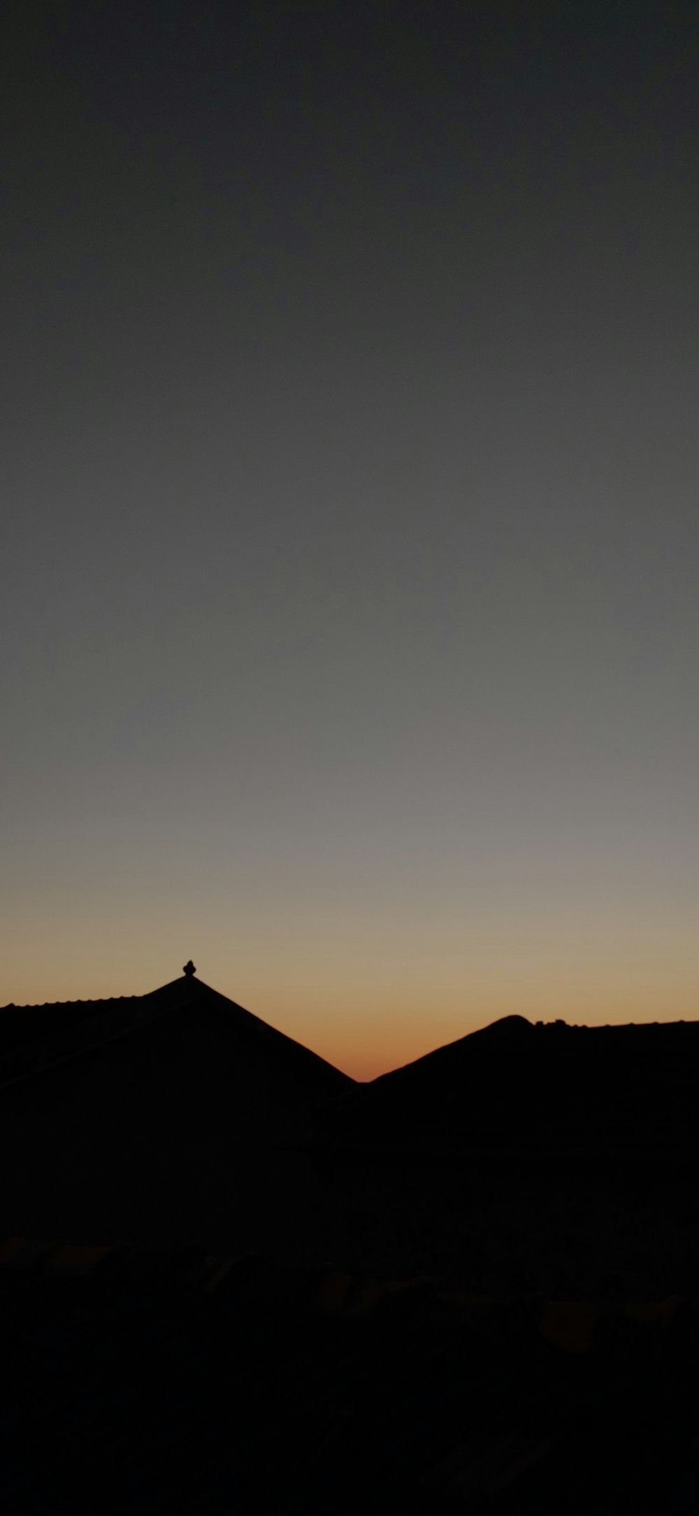 the silhouette of a hill with a cross on top of it