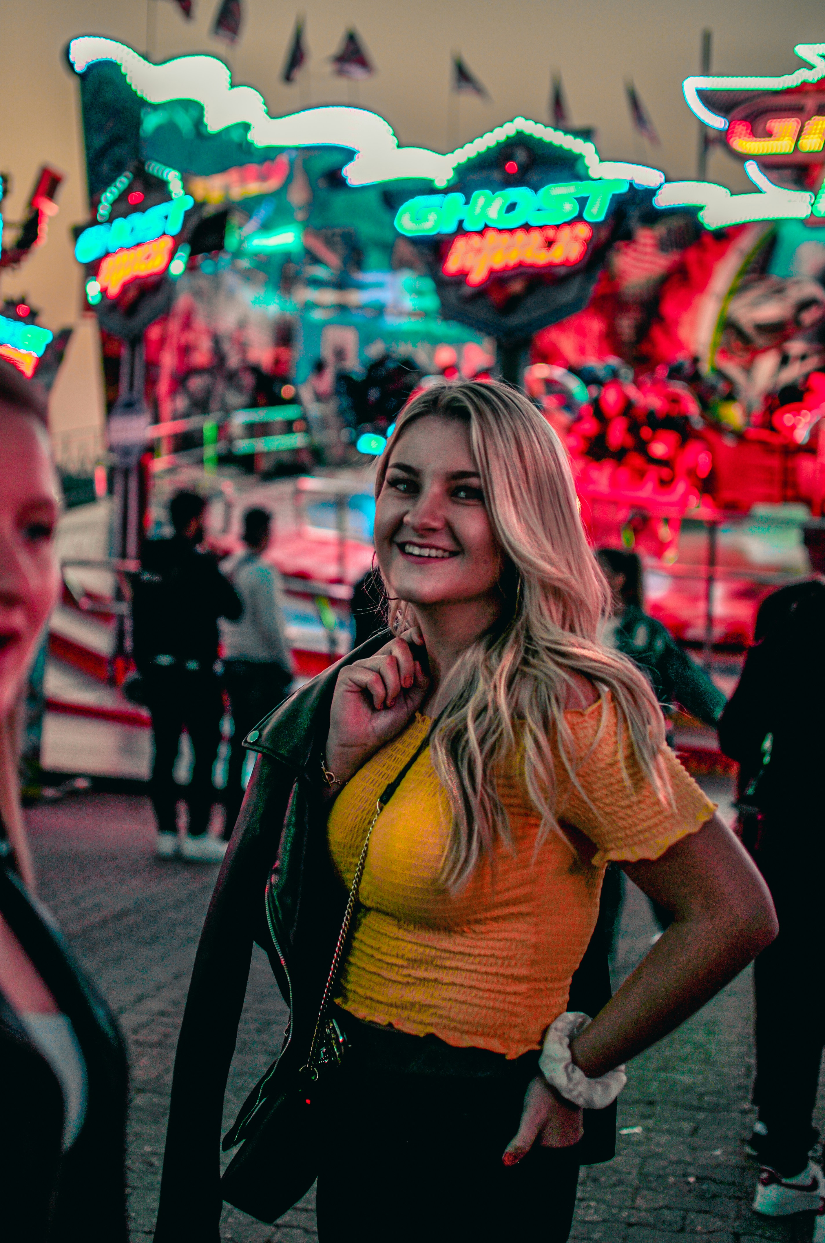 a woman talking on a cell phone in front of a carnival