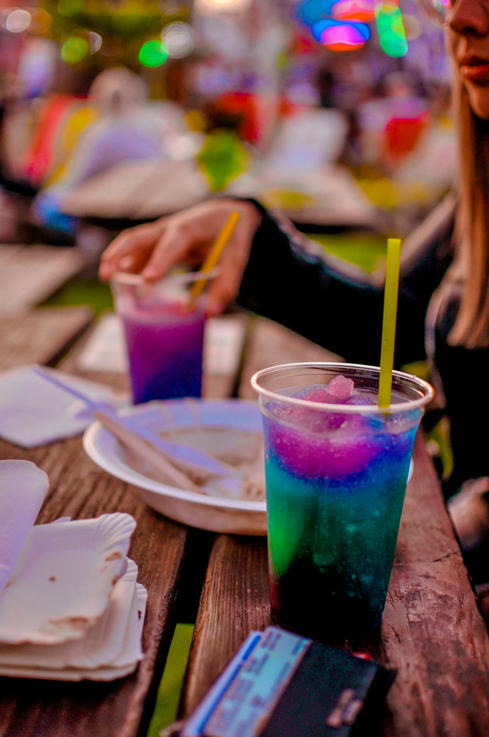 una donna seduta a un tavolo con un drink di fronte a lei