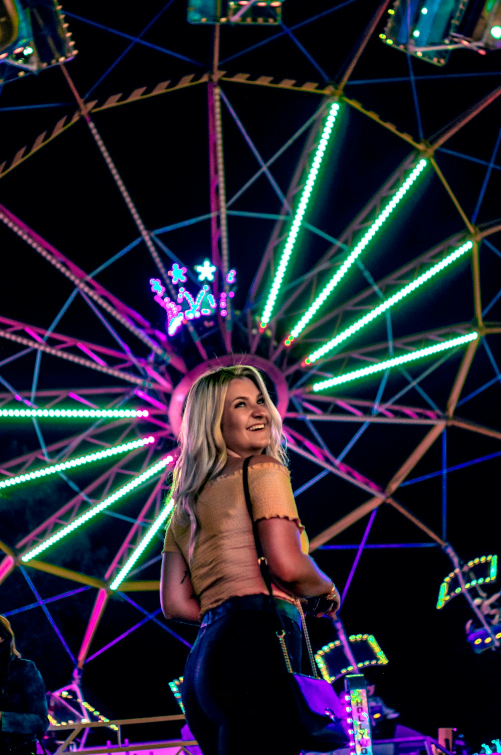 a woman standing in front of a ferris wheel