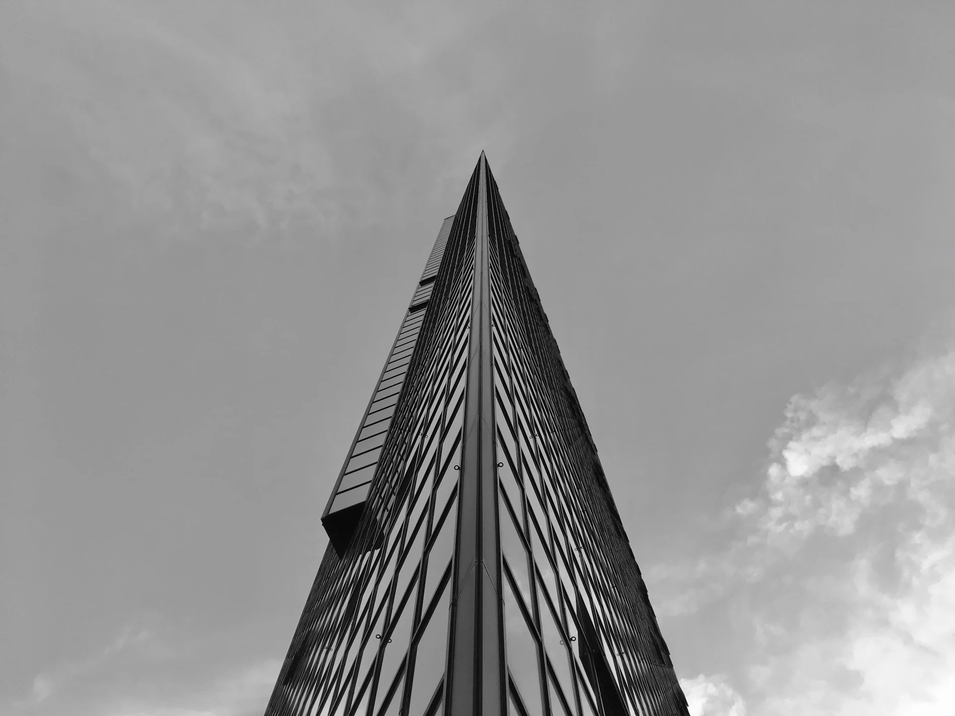 Black and white view of a tall office tower seen from below