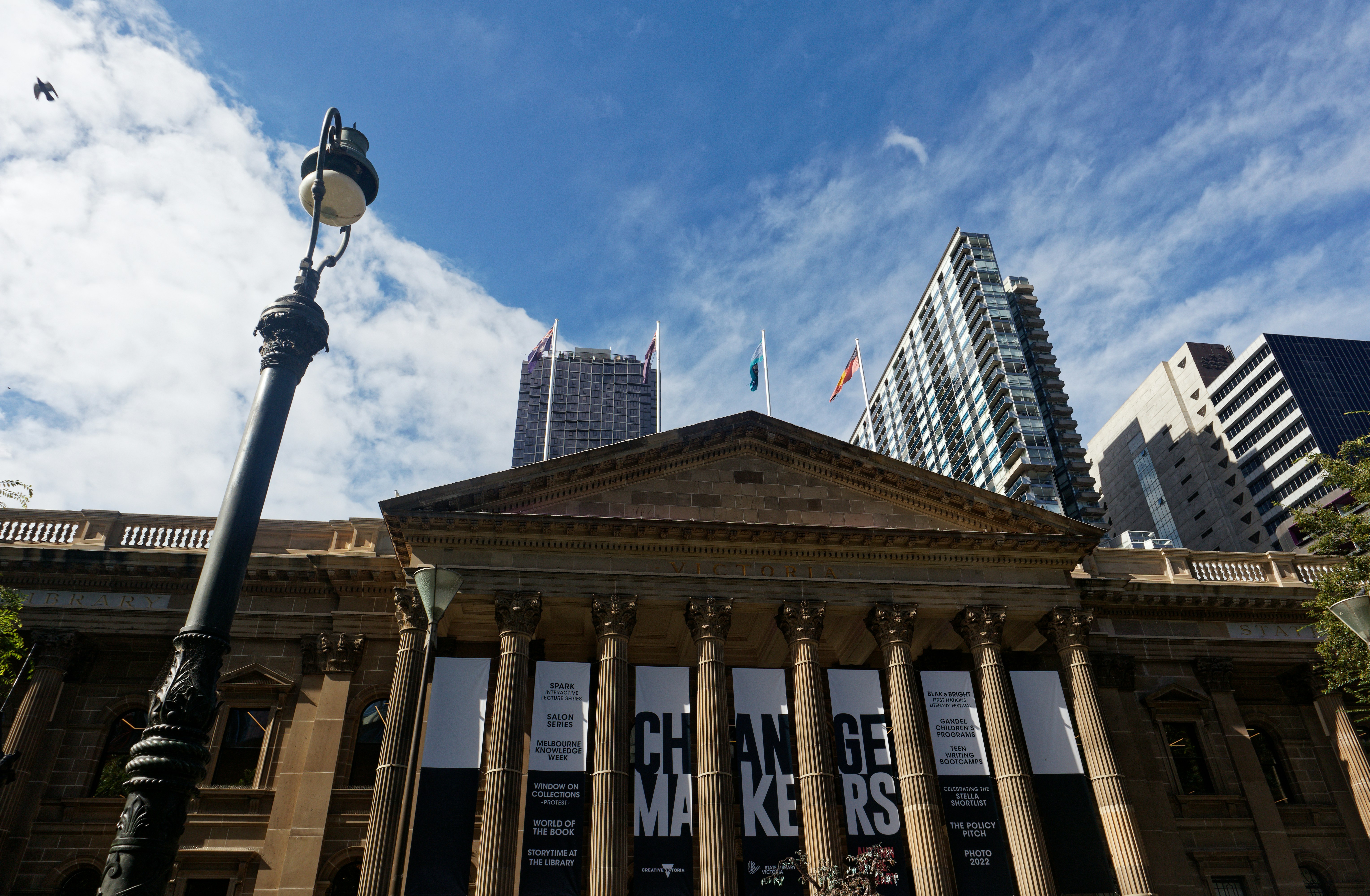 a tall building with columns and a street light in front of it