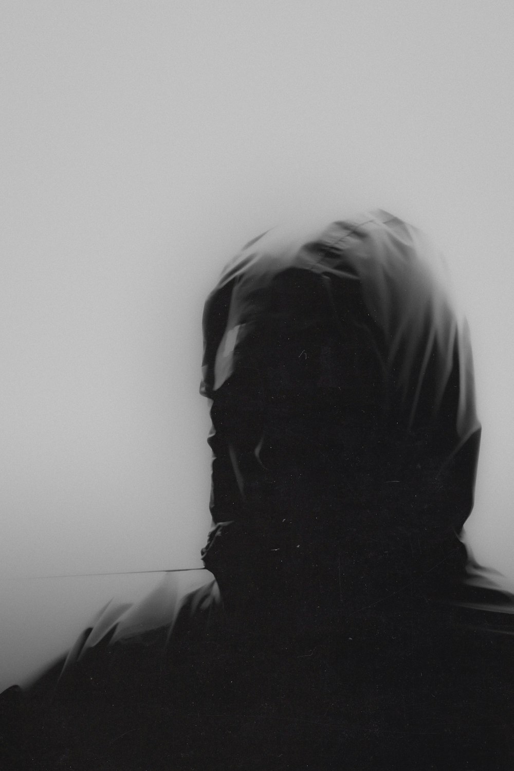 a black and white photo of a person with a hood on