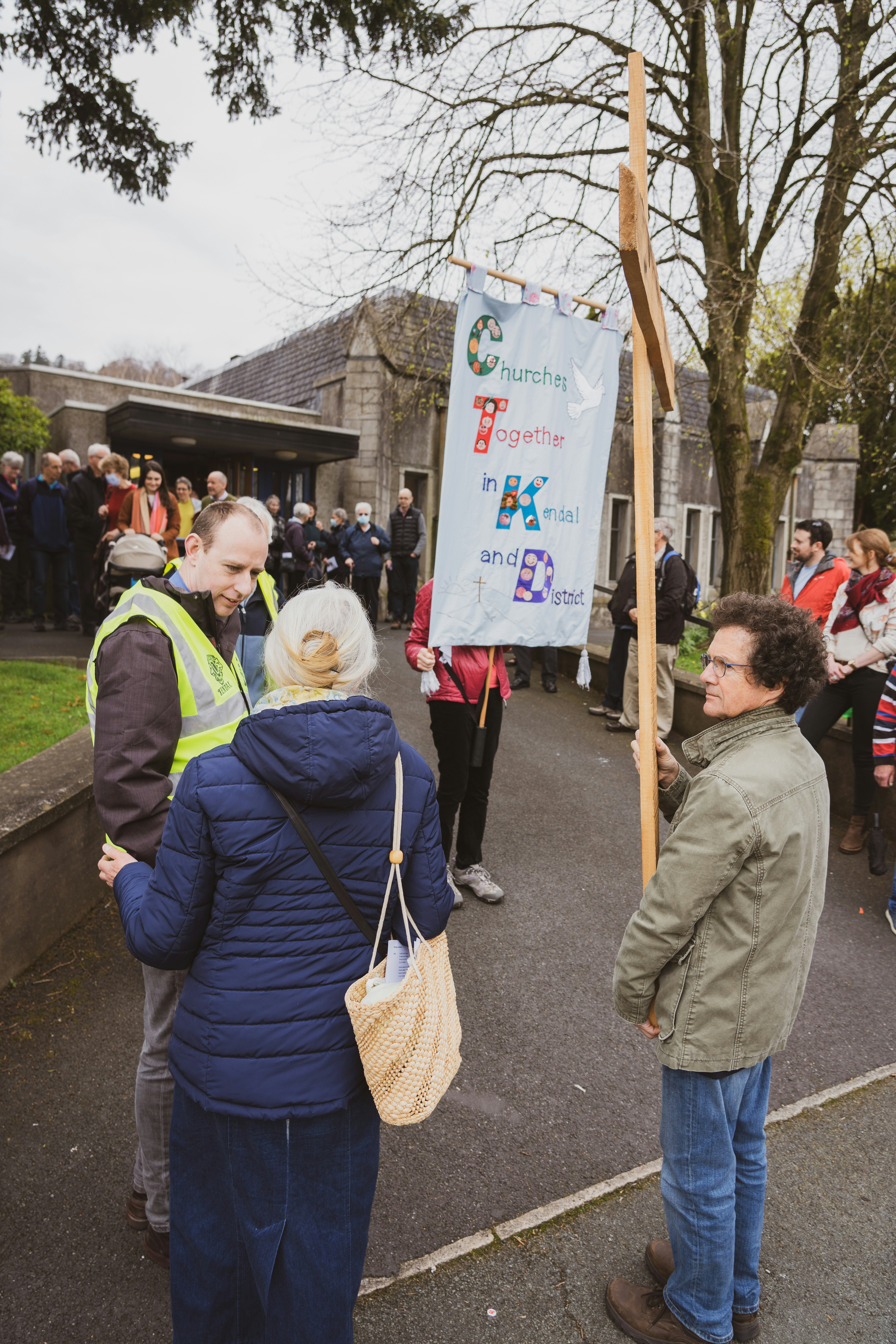 A group of people standing around a sign photo – Free Kendal Image on ...