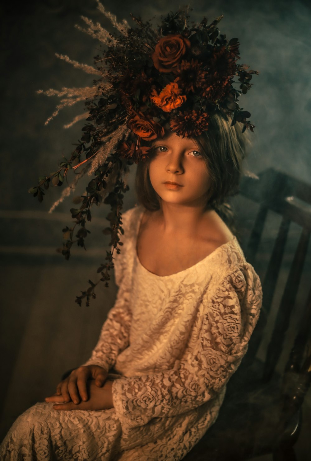 a woman sitting on a chair with a flower crown on her head