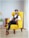 a man sitting in a yellow chair in a room