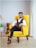 a man sitting in a yellow chair in a room