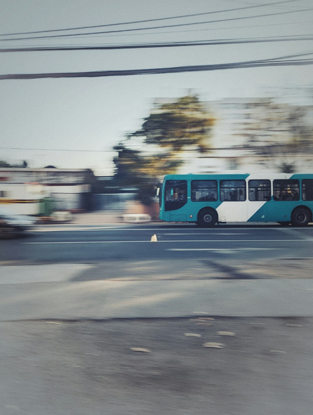 a blue and white bus driving down a street