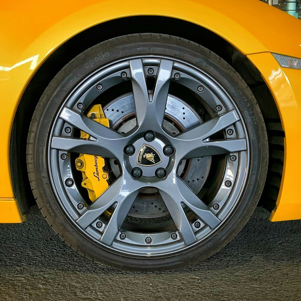 a close up of a yellow sports car wheel