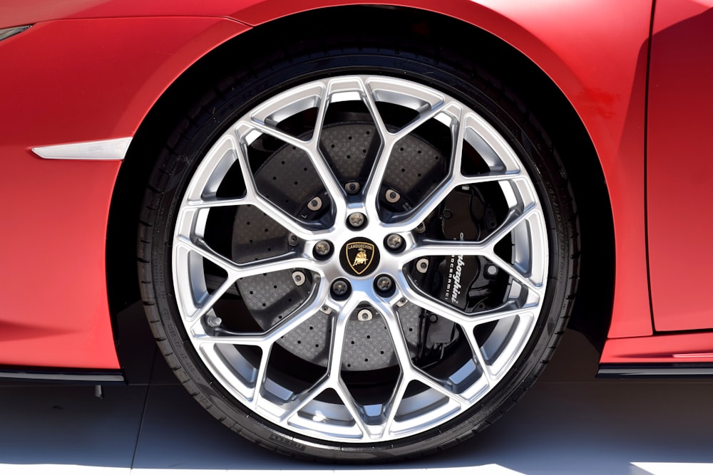 a close up of a wheel on a red sports car