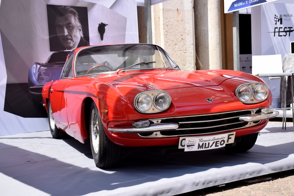 a red sports car on display at a car show