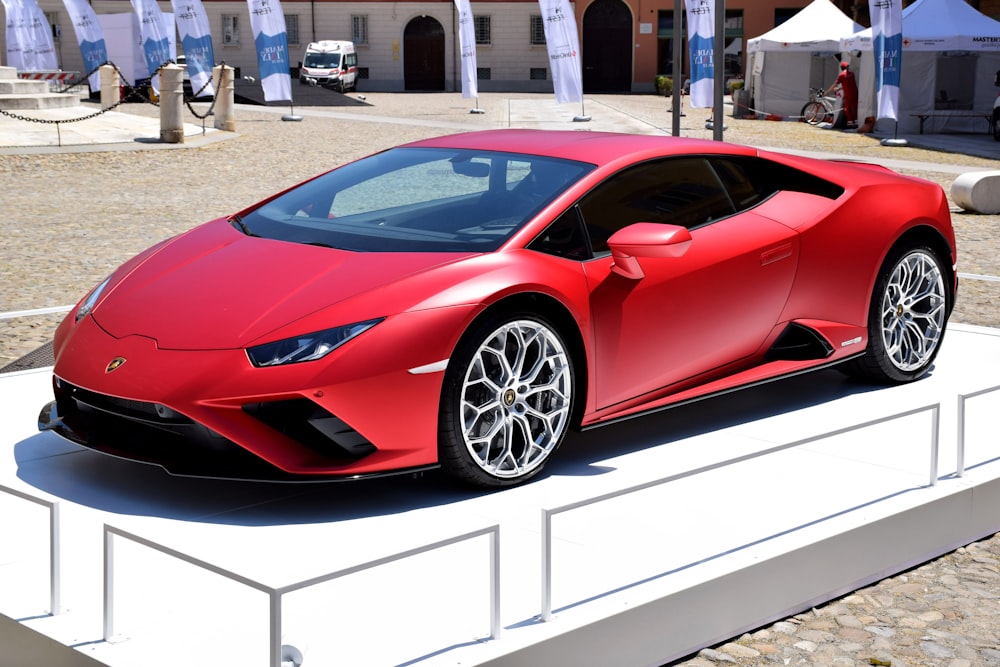 a red sports car is on display at a car show