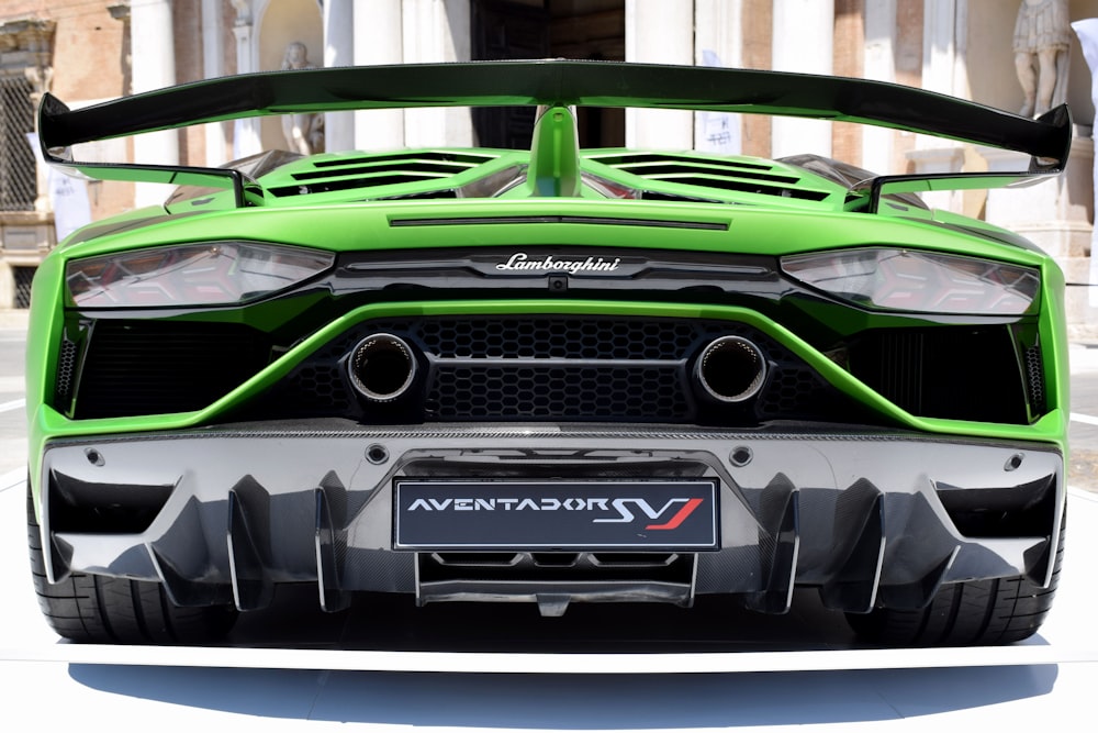 a green sports car parked in front of a building