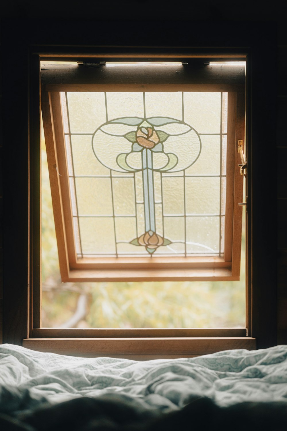 a bed sitting under a stained glass window