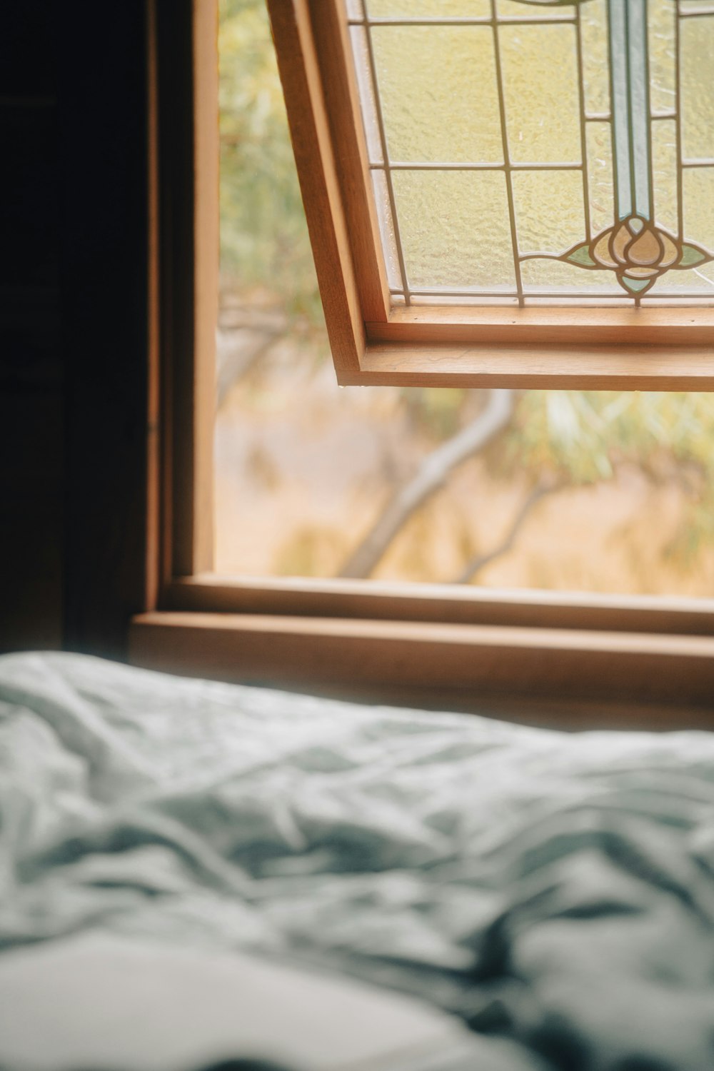 a bed sitting under a stained glass window